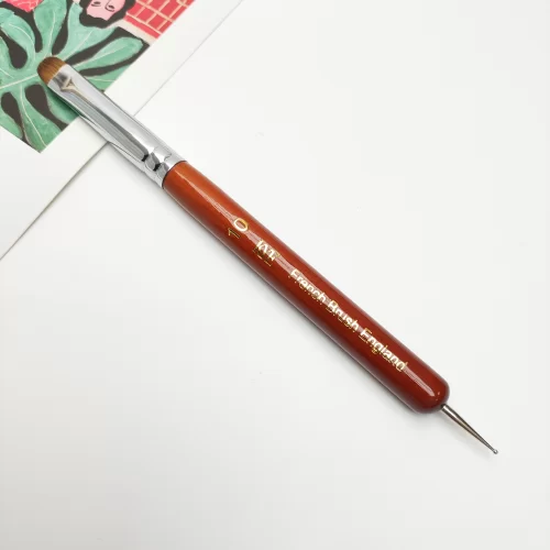 A KYE French Brush with Dotting Tool is sitting on top of a piece of paper.