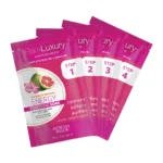 The BareLuxury Complete Pedicure & Manicure set includes four individually packaged beauty treatment sachets labeled "Energy Purifying Soak" with steps 1 through 4, featuring pomegranate and hibiscus ingredients, ideal for a complete pedicure experience.