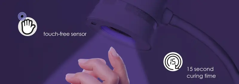 A hand is positioned under a Kupa DUET UV/LED/Desk Lamp - Black, with a glowing light labeled "touch-free sensor" and "15 second curing time," adding a touch of sophistication to the setting.